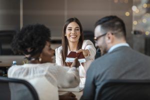 Female travel agent giving tickets to young happy couple