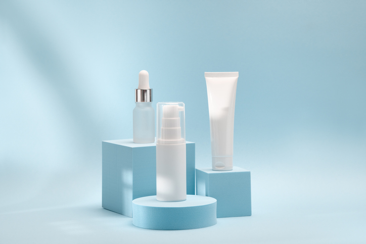 Three cosmetic product mockups on geometric podiums